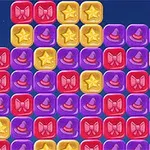 カラフルなブロックが並べられており、赤いリボン、黄色い星、紫の帽子のアイコンが描かれたブロックが見える。