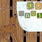 犬が木のフェンスの前で「DOG MAHJONG」と書かれたカラフルなブロックを見上げている。
