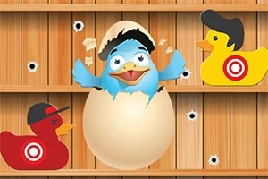 卵から孵化した青い鳥と帽子をかぶった2つのアヒルのおもちゃが木の背景にある。