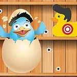卵から孵化した青い鳥と帽子をかぶった2つのアヒルのおもちゃが木の背景にある。
