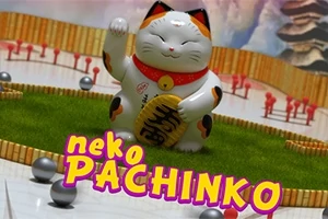 招き猫のフィギュアが緑の台座に置かれ、周囲に小さなボールと「neko PACHINKO」という文字があります。