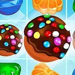 カラフルなチョコレートボールとゼリー、フルーツが並ぶ明るい背景の図。